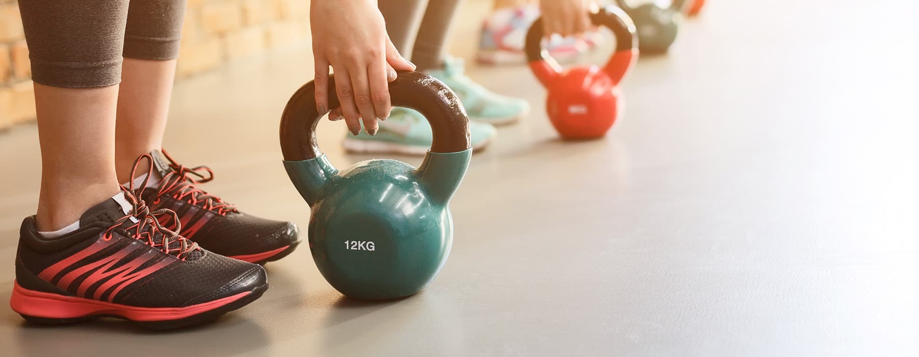 lifestyle image of people with weight balls and workout equipment