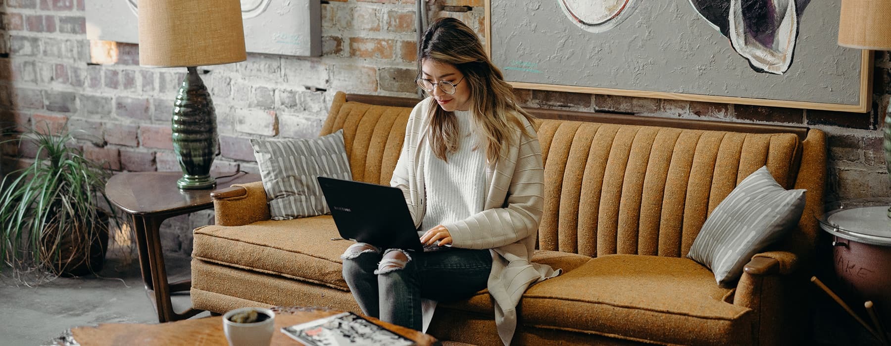 lifestyle image of a professional woman typing inside a comfortable lounge area